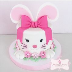 a white cake with pink and green decorations on it's face is decorated like a bunny