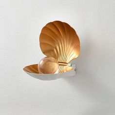 two golden bowls sitting on top of a white shelf next to a wall mounted toothbrush holder