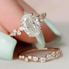 a close up of a person's hand with an engagement ring on their finger