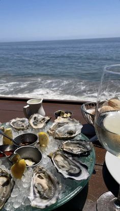 oysters and wine on a table overlooking the ocean