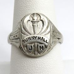 Vintage Sterling silver Class ring Sunny Hill Junior high class of 1943 this ring is a size 8 3/4 this ring is marked sterling and also has a name inscribed on the inner band the ring weighs 6.47 grams the band width at the back of the ring is 3.5mm and the front of the ring is 15.5mm wide PLEASE BE ADVISED PHOTOS ARE CLOSE UPS TO SHOW DETAIL, PLEASE READ DESCRIPTION FOR A BETTER DESCRITION AND UNDERSTANDING OF ITEMS SIZE AND DIMENSIONS.This item is preloved and Vintage. This means it may have s Heirloom Silver Rings For Commemoration, Vintage Silver Engraved Ring Stamped 14k, Antique Silver Engraved Ring For Commemoration, Western Class Rings, Vintage Silver Engraved Ring For Commemoration, Antique Sterling Silver Ring For Commemoration, Antique Silver Engraved Ring With Hallmarks, Art Deco Silver Signet Ring With Polished Finish, Silver Art Deco Signet Ring With Polished Finish