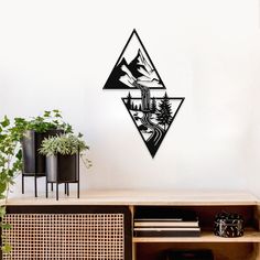 a wall mounted clock with mountains and trees on it