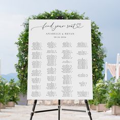 an outdoor seating sign with flowers and greenery on the side for guests to sit in