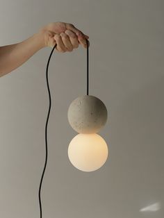 a person is holding two light bulbs in their hand, one with a cord attached to it