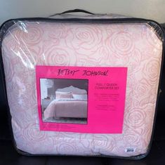 a pink and white bed in a box with its cover pulled up to the side