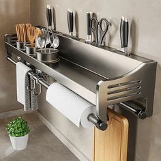 a stainless steel kitchen sink with utensils hanging on the wall