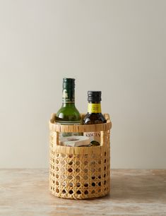 two bottles in a wicker basket on a table