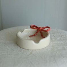 a white bowl with a red bow on it