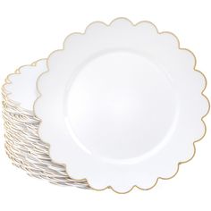 white and gold scalloped plates stacked on top of each other in front of a white background