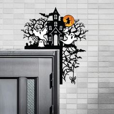 a black cabinet sitting next to a white brick wall with halloween decorations on the top