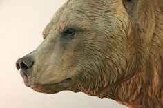 a statue of a bear is shown in front of a white background with the head turned to look like it's looking at something