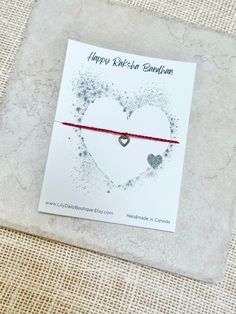 a red string bracelet with a heart on it that says happy valentine's day