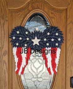 an american flag wreath is hanging on a door with the words ub designs written below it