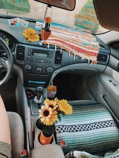 the interior of a car with sunflowers on the dash board and decorative items