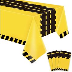 a yellow table cloth with black and white stripes on it, next to matching place mats