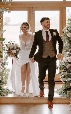 a bride and groom are walking down the aisle at their wedding ceremony in front of an open window