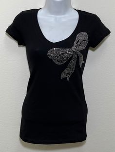 Fabric comprised of 95% cotton and 5% spandex.  Handmade rhinestone t-shirts made in the United States with quality rhinestones. Machine washable. T-shirt style is a fitted V-neck cap sleeve. Size Range:         XXS = 2         XS = 4         S = 6         M = 8         L = 10         XL = 12 Rhinestone Cotton Tops With Short Sleeves, Cotton Rhinestone Short Sleeve Top, Cotton Short Sleeve Top With Rhinestones, Cotton Tops With Rhinestones And Short Sleeves, Embellished Fitted Cotton T-shirt, Fitted Cotton Embellished T-shirt, Graphic Tee T-shirt With Rhinestones, Short Sleeve, Cotton T-shirt With Rhinestones And Short Sleeves, Cotton Short Sleeve T-shirt With Rhinestones