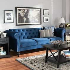 a living room with blue couches and pictures on the wall above them, along with a coffee table