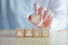 a person pressing buttons on wooden blocks with icons