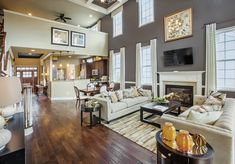 a living room filled with furniture and a flat screen tv mounted on the wall above a fireplace