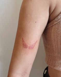 a woman's arm with a small tattoo on the left side of her arm