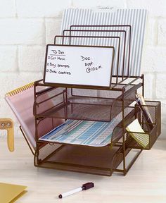 a stack of desk supplies with writing on the white board attached to it and two pen holders next to them