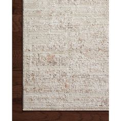 a white rug on top of a wooden floor next to a brown and white wall