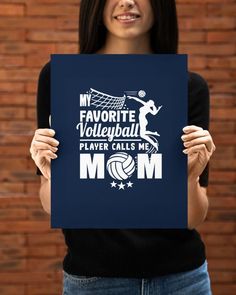 a woman holding up a sign that says my favorite volleyball player calls me mom on it