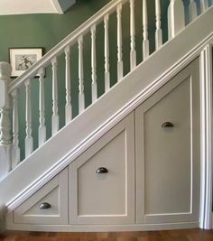 a staircase with white railing and wooden flooring