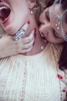 two women with their mouths open and wearing jewelry