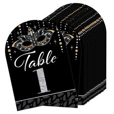 black and gold table number cards with silver glitters on the front, one in the middle