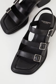 Vagabond Ines triple buckle sandal is the minimal buckle sandals for all-day wear. The style is crafted from black leather featuring adjustable straps with buckle fastening, square toes and padded insoles. The flared block heels. 53mm heels. For long-lasting care: use neutral shoe cream and protecting spray to ensure a longer lifespan for your shoes. 5711-001-20 PIPE AND ROW Clogs Heels, Neutral Shoes, Casual Leather Shoes, Cream Shoes, Buckle Sandals, Your Shoes, Sandals For Sale, Womens Purses, Wearing Black