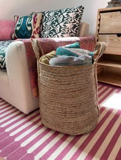 a living room filled with lots of colorful pillows and blankets on top of a striped rug