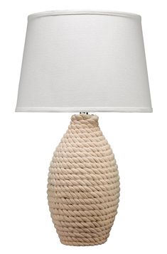 a white table lamp with a roped design on the base and a linen shade