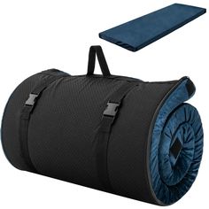 a black and blue duffle bag sitting on top of a white floor next to a mat