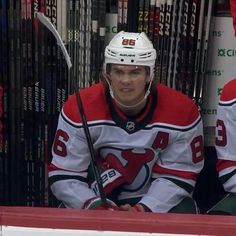 a hockey player sitting on the bench with his stick