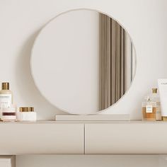 a round mirror sitting on top of a white dresser next to a shelf filled with personal care items