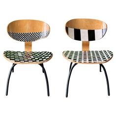 two wooden chairs with black and white designs on them