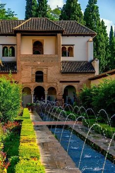 a large building with water fountains in front of it