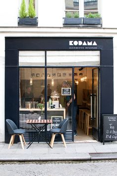 the outside of a coffee shop with tables and chairs