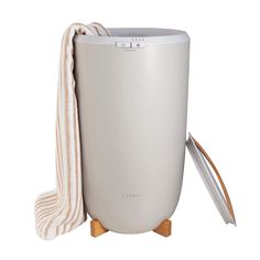 an air purifier with a towel on it and a wooden stand next to it