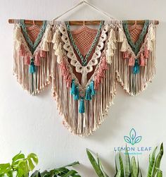 the wall hanging is decorated with macrame and tassels