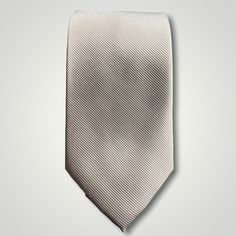 Solid ties are beautifully paired with the more busy of patters of bold stripes and heavy plaids. However, there is something so understated and elegant about a solid tie with a solid suit. Whether that be navy, charcoal or black a silver tie fits well with a white shirt and even a navy blazer with jeans. Silver necktie can also be used with formal wear. Classic Gray Tie For Black Tie Events, Classic Gray Standard Tie And Suit Accessories, Silver Standard Tie For Black Tie Events, Classic Silver Tie For Business, Classic Gray Suit And Tie Accessories For Formal Events, Classic Gray Suit And Tie Accessories For Formal Occasions, Classic Gray Suit And Tie Accessories, Elegant Gray Business Tie, Classic Gray Tie For Semi-formal Occasions