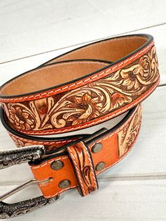 Leather Western style belt with removable buckle. The border is more of a burnt orange / camel leather color with neutral two tone leather tooling Belt Sizes 1.75” wide Small 29”-32” Medium 32”-36” Large 36”-40” XL 40”-44” (buckle is removable with screws) handmade and painted leather tooled and painted by American Darling Not customizable Western Leather Belt, Tack Sets, Western Leather, Painting Leather, Saddle Pads, Purse Strap, Tooled Leather, Leather Tooling, Western Style