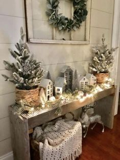 a table topped with potted plants next to a christmas wreath and other decorations on top of it