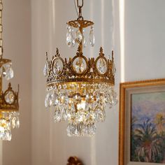 a chandelier hanging from the ceiling in a room with pictures on the wall