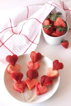 strawberries are arranged in the shape of hearts on a plate