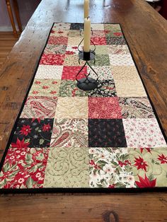 a table with a candle on top of it and a quilted placemat in the middle