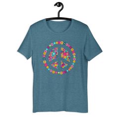 The vintage or retro vibes of the 60s 70s are on this spring inspired floral peace loving gift item blooming with flora . For a nostalgic pacifist or peace movement supporter , it's a throwback icon of world peace love happiness and kindness . This graphic design would be the perfect gift to celebrate any great occasion or event like a birthday , anniversary , Thanksgiving holiday or the Christmas holidays . You've now found the staple t-shirt of your wardrobe. It's made of a thicker, heavier co Hippie Multicolor T-shirt For Spring, Hippie Letter Print Tops For Spring, Vintage Multicolor Spring T-shirt, Spring Retro Screen Print T-shirt, Retro Short Sleeve T-shirt With Floral Print, Retro Style Blue T-shirt For Spring, Vintage Printed Spring T-shirt, Summer Crew Neck Top With Peace Sign, Hippie T-shirt With Screen Print For Spring