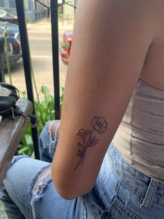 a woman's arm with a flower tattoo on the left side of her right arm